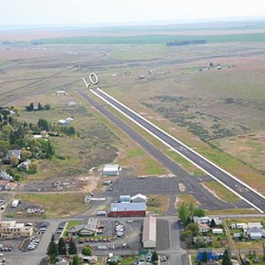 Pru Field Airport runway located near grass and a city center.