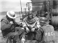Diver Johnny Bacon, a 15-year veteran bridge worker, takes a break in his 200 lb. diving suit, May 1939 TPL 6172